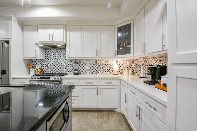 910 11th St, South Houston, TX 77587 - kitchen with stainless steel appliances, under cabinet range hood, white cabinets, backsplash, and glass insert cabinets