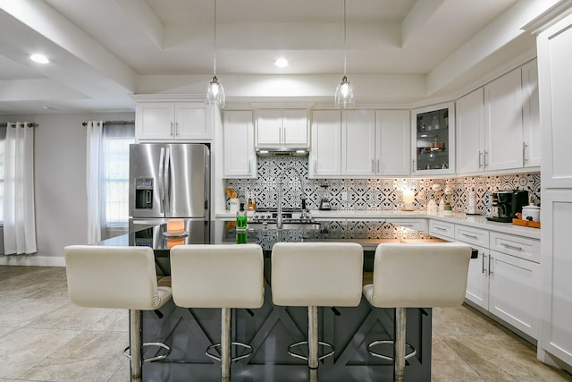 910 11th St, South Houston, TX 77587 - kitchen with stainless steel fridge, a tray ceiling, decorative backsplash, and recessed lighting