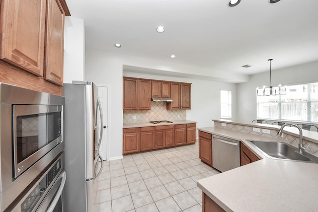 3214 Oak Park Ln, Missouri City, TX 77459 - kitchen featuring stainless steel appliances, backsplash, brown cabinetry, light tile patterned flooring, and light countertops