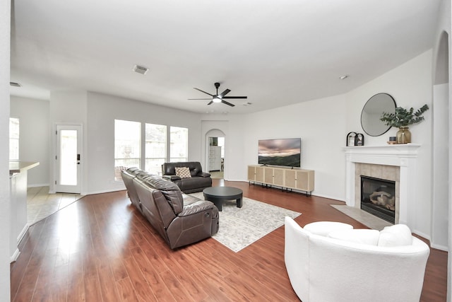 3214 Oak Park Ln, Missouri City, TX 77459 - living room with a fireplace, a ceiling fan, wood finished floors, and arched walkways