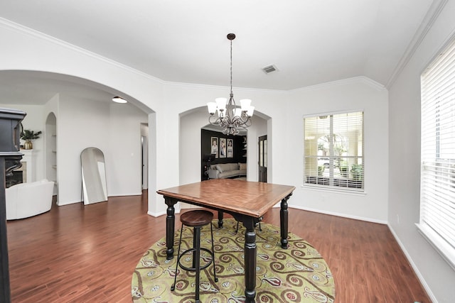 3214 Oak Park Ln, Missouri City, TX 77459 - dining space featuring dark wood finished floors, a chandelier, arched walkways, healthy amount of natural light, and ornamental molding