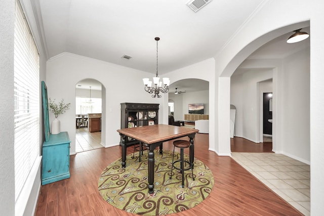 3214 Oak Park Ln, Missouri City, TX 77459 - dining room with a chandelier, ornamental molding, wood finished floors, and arched walkways