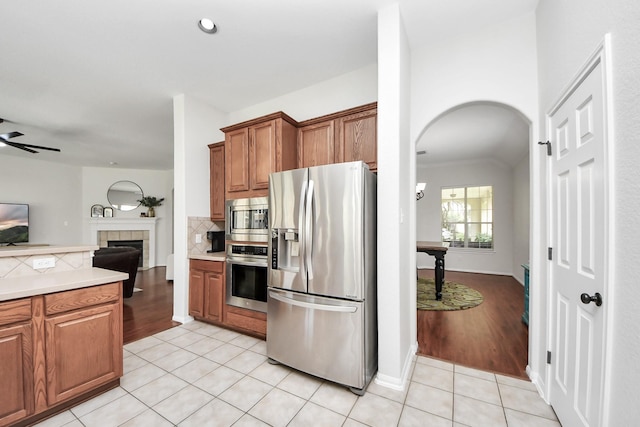 3214 Oak Park Ln, Missouri City, TX 77459 - kitchen featuring stainless steel appliances, arched walkways, light countertops, light tile patterned flooring, and recessed lighting