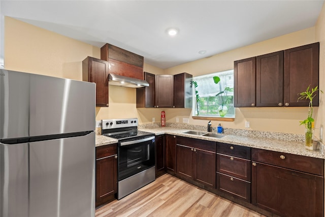 1415 Pony Ln, Simonton, TX 77485 - kitchen with appliances with stainless steel finishes, extractor fan, light wood-style flooring, dark brown cabinetry, and light stone counters