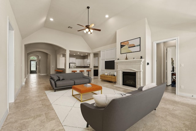 1719 Quail Ridge Dr, Katy, TX 77493 - living area with vaulted ceiling, a ceiling fan, arched walkways, a glass covered fireplace, and recessed lighting