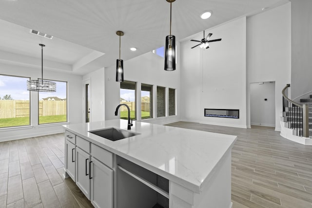 2806 Nova Beach Dr, Texas City, TX 77568 - kitchen featuring a glass covered fireplace, hanging light fixtures, light wood finished floors, light stone counters, and recessed lighting