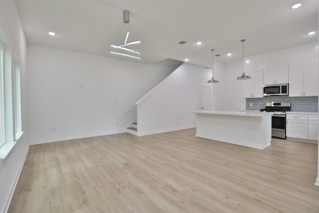 9343 Lavender St, North Houston, TX 77016 - kitchen with appliances with stainless steel finishes, backsplash, white cabinetry, light wood-style flooring, and recessed lighting