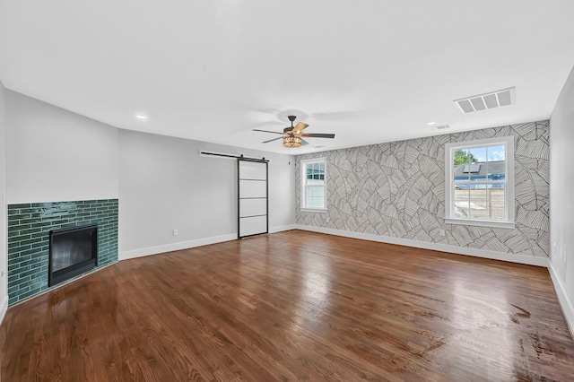 3343 Tampa St, Houston, TX 77021 - unfurnished living room featuring a barn door, a ceiling fan, wood finished floors, a tile fireplace, and recessed lighting