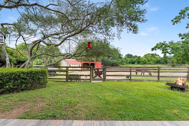 4205 Wade Rd, Brookshire, TX 77423 - view of green lawn featuring a fire pit, an outdoor structure, and an exterior structure