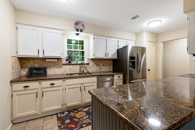 4205 Wade Rd, Brookshire, TX 77423 - kitchen featuring stainless steel appliances, decorative backsplash, white cabinetry, and dark stone countertops