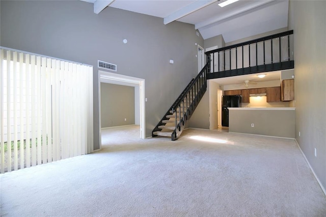 13002 Leader Unit 906, Houston, TX 77072 - unfurnished living room featuring high vaulted ceiling, beam ceiling, light colored carpet, stairs, and a ceiling fan