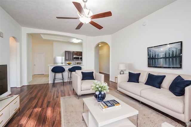 21335 Riverside Ridge Ln, Katy, TX 77449 - living area featuring arched walkways, ceiling fan, and dark wood-style flooring