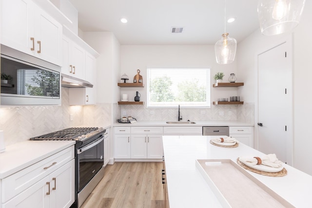 1615 Erin St, Houston, TX 77009 - kitchen with appliances with stainless steel finishes, open shelves, under cabinet range hood, light countertops, and recessed lighting