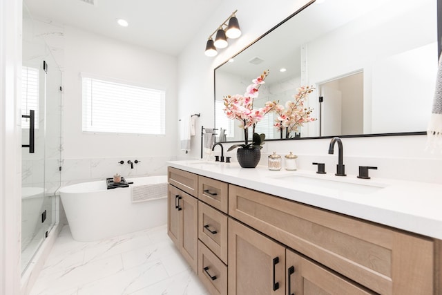 1615 Erin St, Houston, TX 77009 - full bath featuring double vanity, a freestanding tub, healthy amount of natural light, marble look tile flooring, and recessed lighting