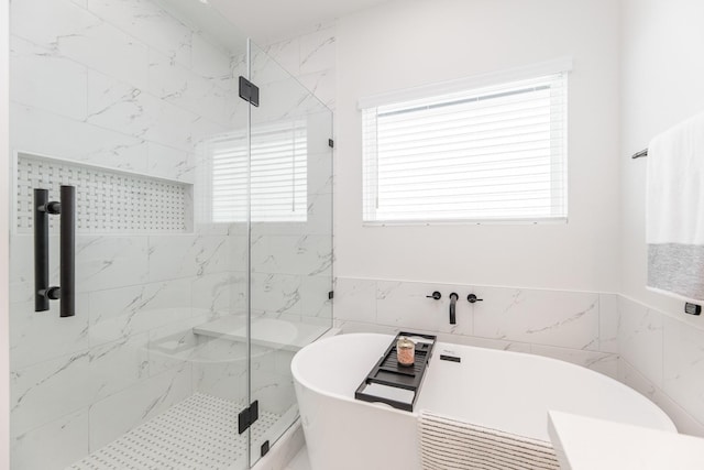 1615 Erin St, Houston, TX 77009 - bathroom featuring a marble finish shower, a freestanding bath, plenty of natural light, and tile walls