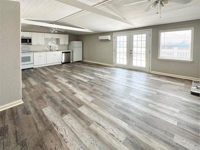 323 Texas St, Freeport, TX 77541 - unfurnished living room with ceiling fan, a wall mounted air conditioner, french doors, wood finished floors, and a wood ceiling with exposed beams
