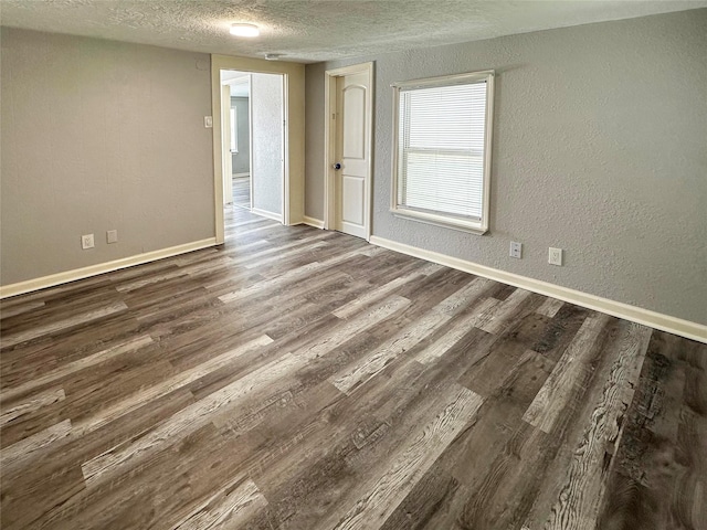 323 Texas St, Freeport, TX 77541 - spare room with a textured ceiling, dark wood-type flooring, and a textured wall