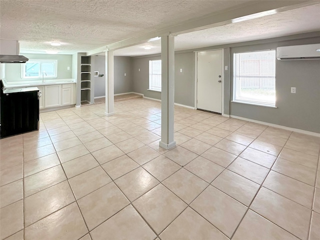 323 Texas St, Freeport, TX 77541 - unfurnished living room featuring a wall mounted air conditioner, light tile patterned floors, a textured ceiling, and healthy amount of natural light
