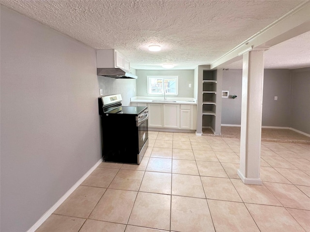 323 Texas St, Freeport, TX 77541 - kitchen with stainless steel electric stove, under cabinet range hood, white cabinets, light tile patterned floors, and a textured ceiling