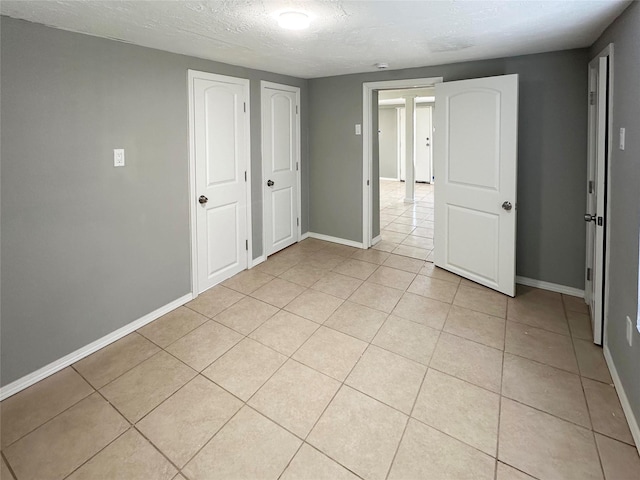 323 Texas St, Freeport, TX 77541 - unfurnished bedroom featuring light tile patterned flooring and a textured ceiling