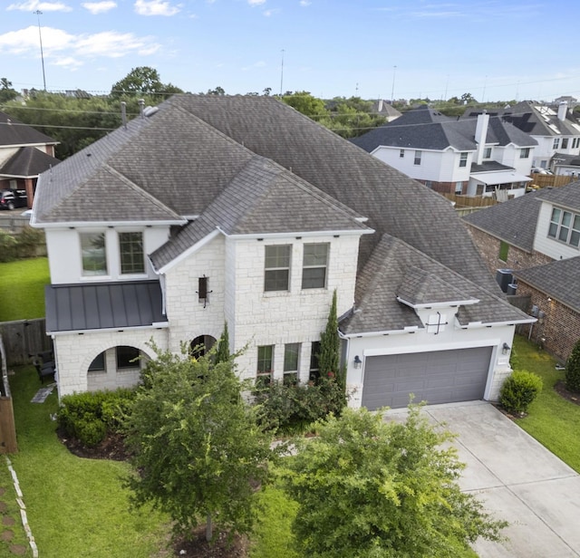 6126 Garden Lakes Ln, Sugar Land, TX 77479 - view of front of house with a shingled roof, a standing seam roof, a garage, a residential view, and concrete driveway