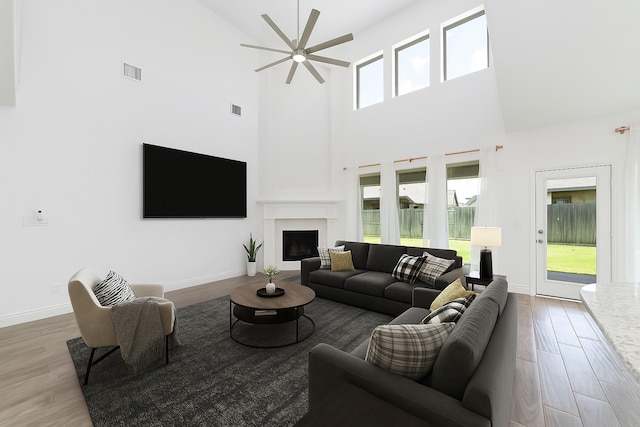 13731 Pedernales Ct, Cypress, TX 77429 - living area with a ceiling fan, high vaulted ceiling, wood finished floors, and a fireplace