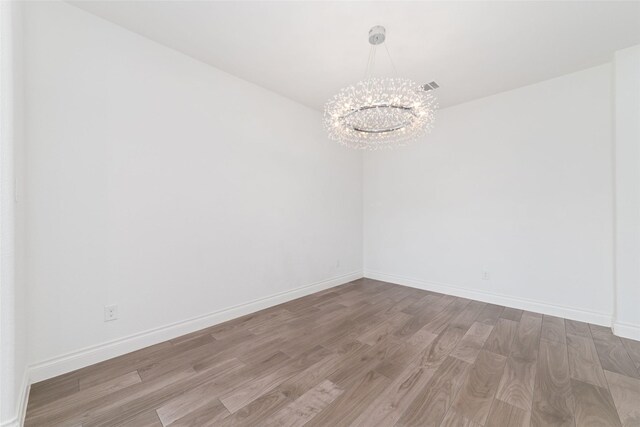 13731 Pedernales Ct, Cypress, TX 77429 - unfurnished room with a chandelier and wood finished floors