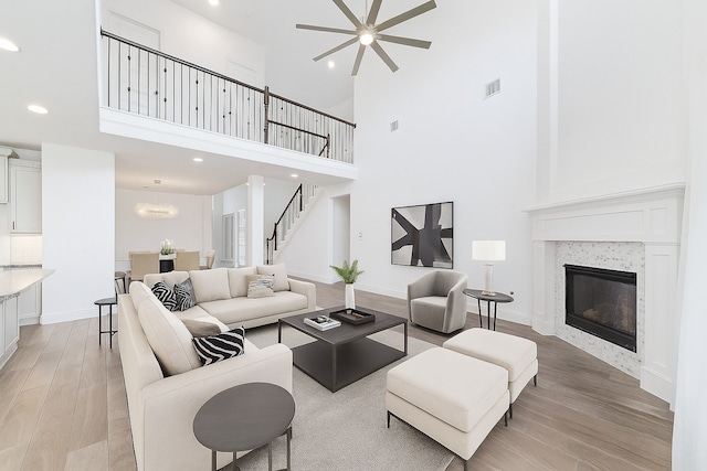 13731 Pedernales Ct, Cypress, TX 77429 - living room with a high ceiling, light wood-style floors, ceiling fan, recessed lighting, and a tile fireplace
