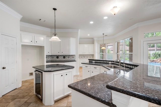 3207 W Benders Landing Blvd, Spring, TX 77386 - kitchen featuring a large island, decorative backsplash, ornamental molding, beverage cooler, and white cabinets