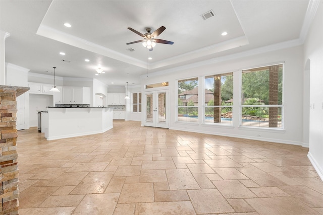 3207 W Benders Landing Blvd, Spring, TX 77386 - unfurnished living room with a tray ceiling, stone tile floors, ceiling fan, plenty of natural light, and recessed lighting