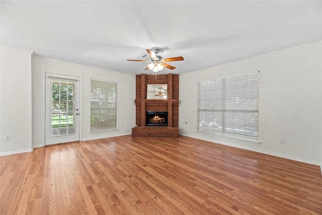 15207 Hillside Park Way, Cypress, TX 77433 - unfurnished living room featuring ceiling fan, light wood-style floors, crown molding, and a brick fireplace