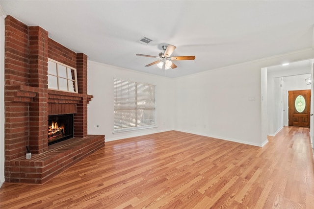15207 Hillside Park Way, Cypress, TX 77433 - unfurnished living room with light wood-style flooring, a fireplace, a ceiling fan, and crown molding