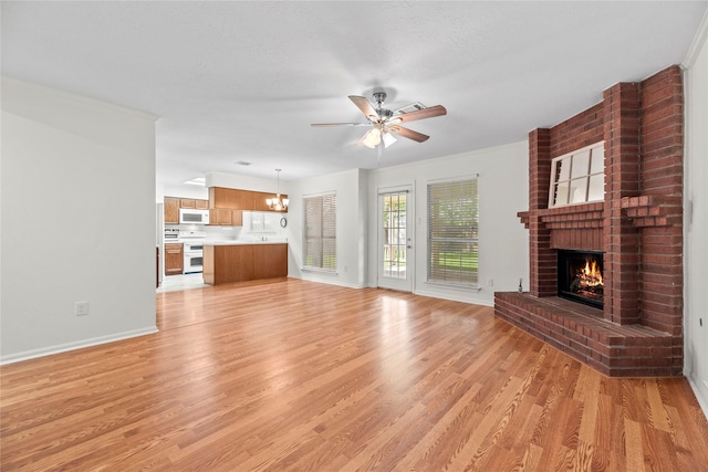 15207 Hillside Park Way, Cypress, TX 77433 - unfurnished living room featuring a brick fireplace, light wood-type flooring, and a ceiling fan