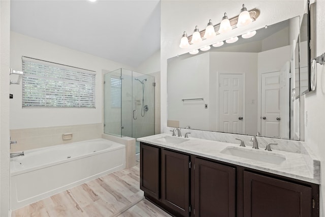 15207 Hillside Park Way, Cypress, TX 77433 - bathroom featuring a shower stall, a garden tub, double vanity, vaulted ceiling, and wood finished floors