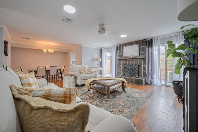 14666 Perthshire Rd Unit F, Houston, TX 77079 - living area with crown molding, a chandelier, hardwood / wood-style floors, and a stone fireplace