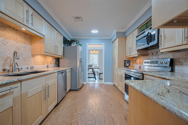 14666 Perthshire Rd Unit F, Houston, TX 77079 - kitchen featuring appliances with stainless steel finishes, light wood finished floors, ornamental molding, healthy amount of natural light, and a chandelier