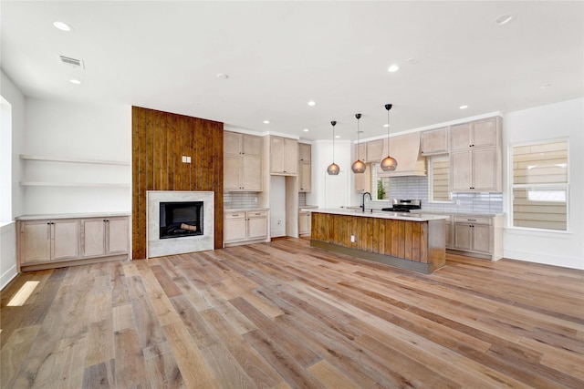 5439 Darling St, Houston, TX 77007 - kitchen featuring light wood-type flooring, light countertops, tasteful backsplash, open floor plan, and a center island with sink