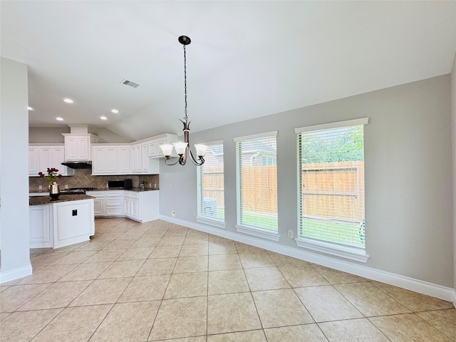 27907 Brandy Creek Ln, Fulshear, TX 77441 - kitchen featuring dark countertops, backsplash, lofted ceiling, light tile patterned flooring, and a chandelier