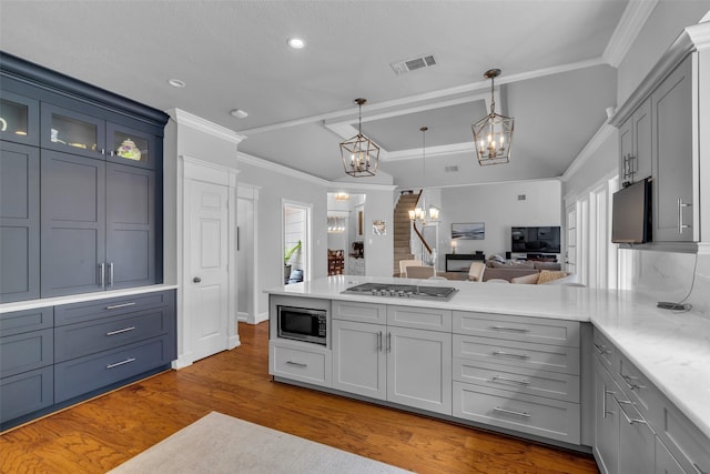 8723 Kennet Valley Rd, Spring, TX 77379 - kitchen featuring appliances with stainless steel finishes, a chandelier, a peninsula, wood finished floors, and ornamental molding