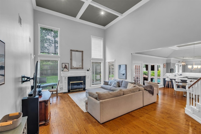 8723 Kennet Valley Rd, Spring, TX 77379 - living room with a high ceiling, crown molding, light wood-style floors, a high end fireplace, and a chandelier