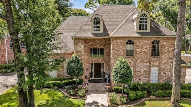 8723 Kennet Valley Rd, Spring, TX 77379 - view of front facade with brick siding, a shingled roof, and a front yard