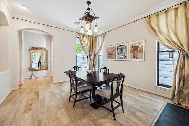 2019 Hazard St, Houston, TX 77019 - dining space featuring arched walkways, light wood-style floors, and ornamental molding