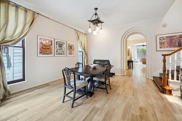 2019 Hazard St, Houston, TX 77019 - dining room featuring arched walkways, light wood-type flooring, ornamental molding, and stairs