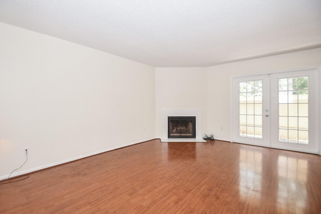 2120 El Paseo St Unit 2905, Houston, TX 77054 - unfurnished living room featuring wood finished floors, a fireplace with flush hearth, and french doors