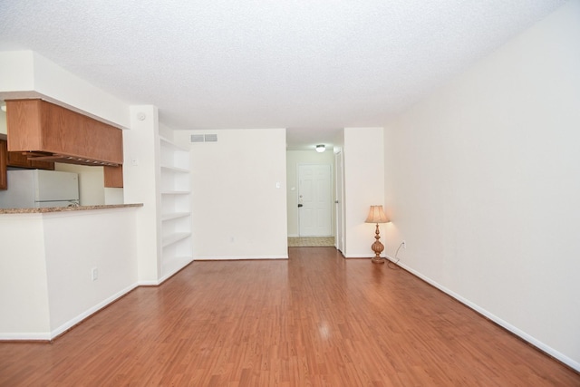 2120 El Paseo St Unit 2905, Houston, TX 77054 - unfurnished living room featuring wood finished floors, built in features, and a textured ceiling