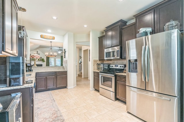 12602 Browning Dr, Montgomery, TX 77356 - kitchen with appliances with stainless steel finishes, recessed lighting, a chandelier, light stone countertops, and decorative backsplash