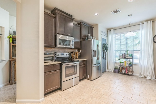 12602 Browning Dr, Montgomery, TX 77356 - kitchen featuring appliances with stainless steel finishes, dark brown cabinets, decorative light fixtures, recessed lighting, and light tile patterned floors