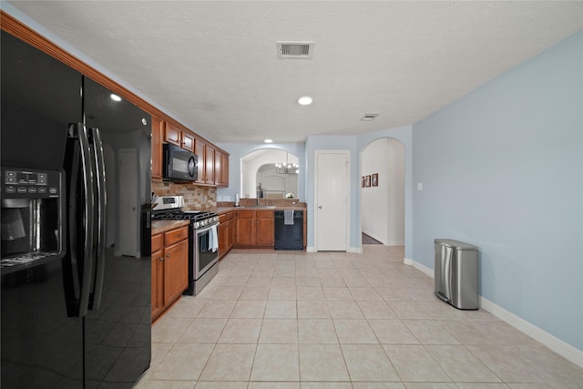 1111 Cypress Ln, Dayton, TX 77535 - kitchen featuring black appliances, arched walkways, decorative backsplash, brown cabinets, and light tile patterned flooring