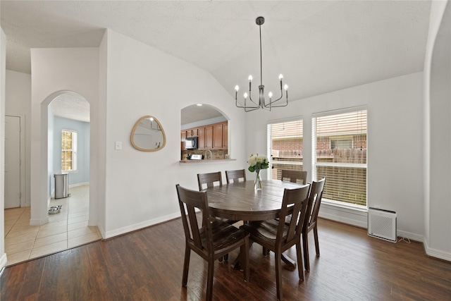 1111 Cypress Ln, Dayton, TX 77535 - dining area with arched walkways, wood finished floors, a chandelier, and lofted ceiling