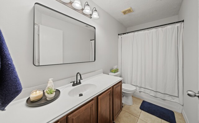 1111 Cypress Ln, Dayton, TX 77535 - bathroom with vanity, tile patterned flooring, a textured ceiling, and shower / bathtub combination with curtain